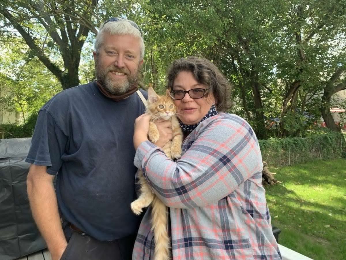 A couple holding their Maine Coon after homecoming